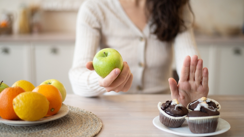 Osoba bira jabuku umesto kolača